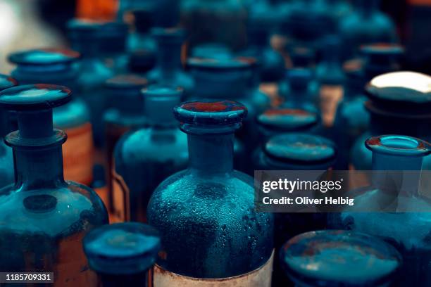 large number of antique pharmacy bottles made of blue glass - alchemy stock-fotos und bilder