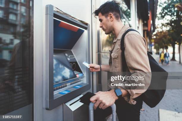 tourist withdrawing money on the atm - man atm smile stock pictures, royalty-free photos & images