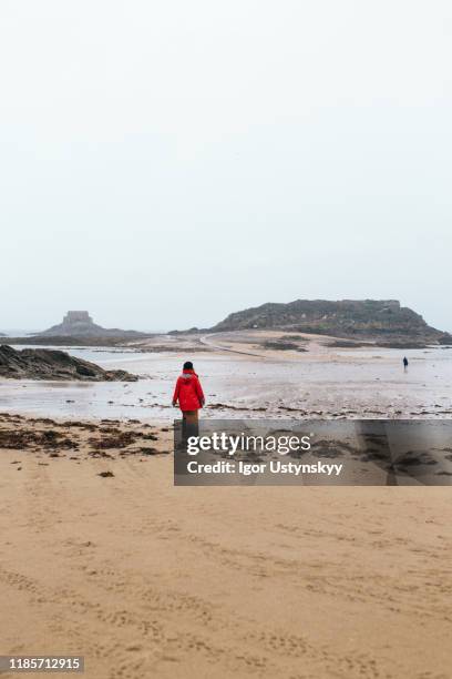 rear view of woman walking at beach - サン マロ ストックフォトと画像