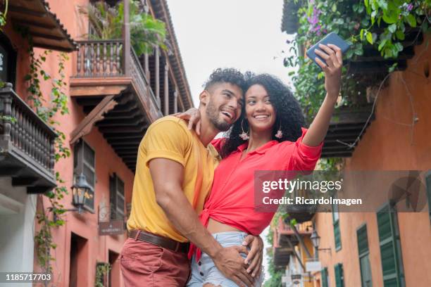 latin couple in the historic streets of cartagena where they take a selfie - cartagena colombia stock pictures, royalty-free photos & images