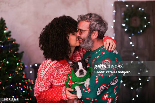 adult couple kissing at christmas time - christmas kit stock-fotos und bilder