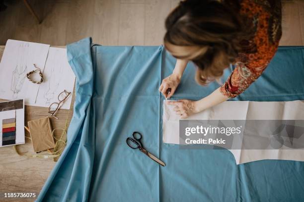 making a few minor adjustments - woman fashion designer stock pictures, royalty-free photos & images