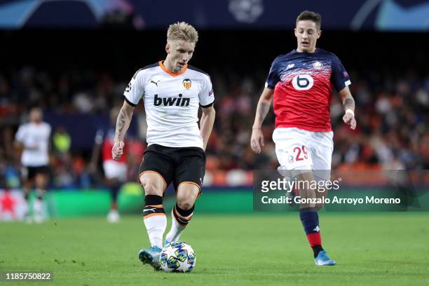 Daniel Wass of Valencia passes the ball while under pressure from Domagoj Bradaric of Lille OSC during the UEFA Champions League group H match...