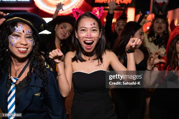 aziatische vrouwelijke vrienden in halloween kostuum wandelen en dansen op night street - adult halloween party stockfoto's en -beelden