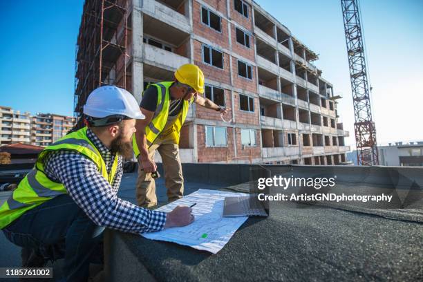 architekten überprüfen baupläne auf der baustelle. - wiederbelebung stock-fotos und bilder