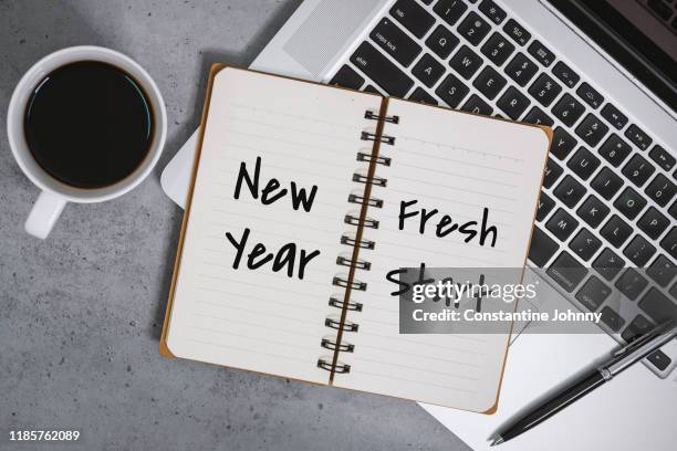 new year fresh start on notebook with laptop over work desk - resolução de ano novo - fotografias e filmes do acervo