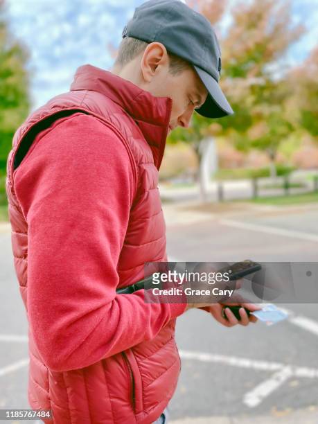 man uses smart phone outdoors - a fall from grace - fotografias e filmes do acervo