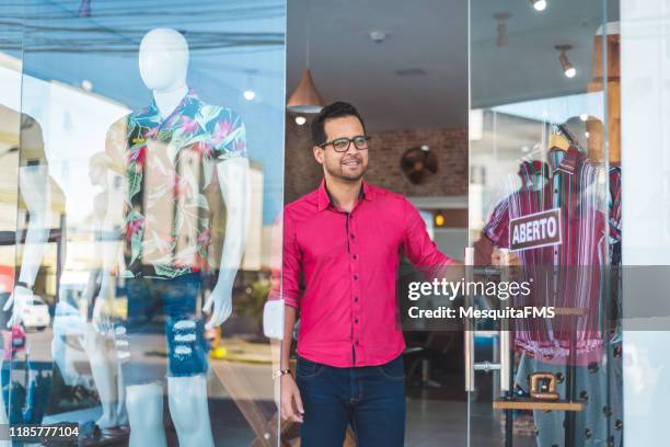 vendedor que abre a loja de roupa - abrindo - fotografias e filmes do acervo