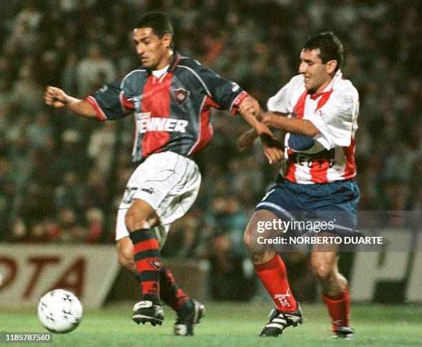 El jugador de Estudiantes de Merida, Jorge Vergara intenta detener al footbolista de Cerro Porteno Guido Alvareja, el 12 de Mayo de 1999, en...
