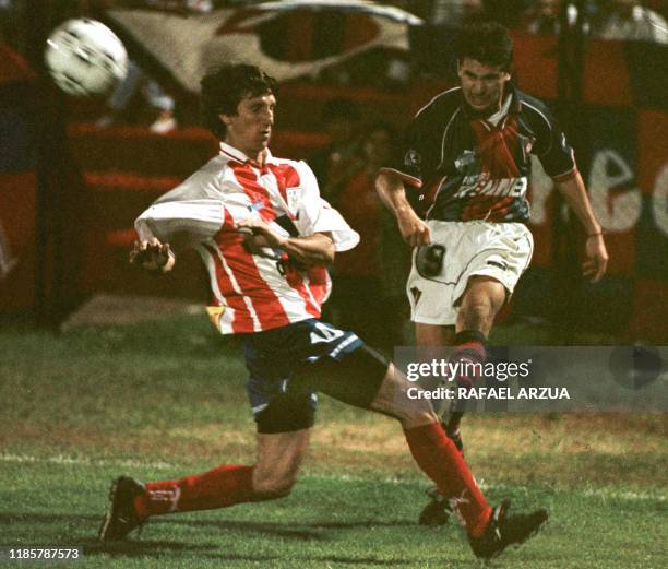 El jugador de Estudiantes de Merida Luis Aguirre intenta obstruir el tiro de Mauro Caballero de Cerro Porteno el 12 de Mayo de 1999 en Asuncion,...