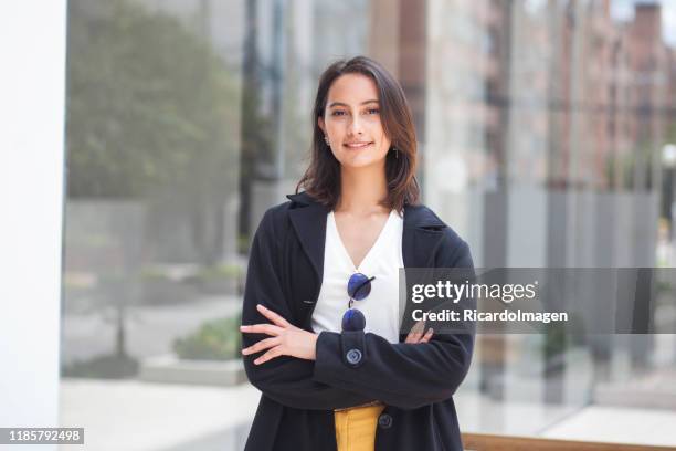 portret van de vrouwelijke kantoormedewerker die op haar werkplek aankomt - colombian ethnicity stockfoto's en -beelden