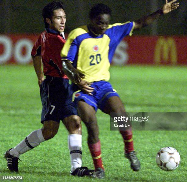 Mark Gonzalez of Colombia battles for the ball with Chilean player Miguel Abrigo Farias, 10 January 2003, at the Campus de Colonia Stadium, 177km...