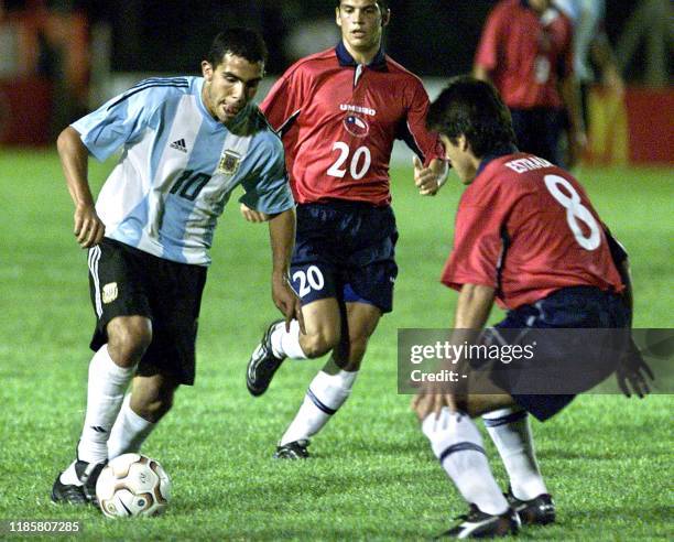 Alberto Tevez of the Argentinian team, tries to keep the ball from Chilean players Marcos Estrada and Mark Gonzalez, 08 January 2003, at the Campus...