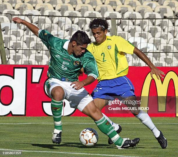 Luis Gutierrez of the Bolivian team, battles for the ball against Daniel Alvez of Brazil, 07 January 2003 at the Cenetario Stadium in Montevideo,...