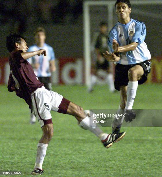 Argentinian Marcelo Carrusca battles for the ball with Evelio Hernandez of the Venezuelan team, 10 January 2003, at the Campus de Colonia Stadium,...