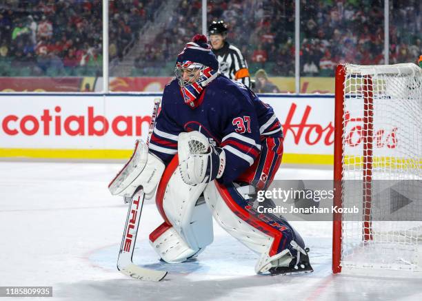 Goaltender Connor Hellebuyck of the Winnipeg Jets guards the net during overtime action against the Calgary Flames during the 2019 Tim Hortons NHL...