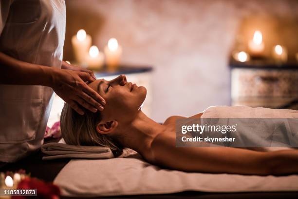 mujer disfrutando de masaje de cabeza durante el tratamiento de belleza en el spa. - spa treatment fotografías e imágenes de stock