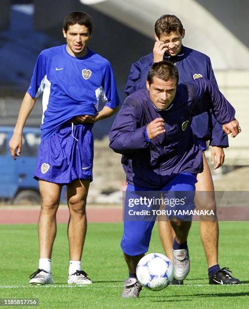 Argentine football club Boca Juniors forward Marcelo Alejandro Delgado dribbles the ball while midfielder Juan Roman Riquelme and Cristian Alberto...