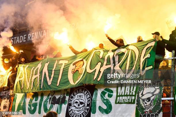 Saint Etienne's supporters hold flares and banners during the French Ligue 1 football match between Stade Rennais Football Club and AS Saint Etienne...