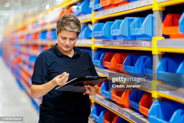 trabalhador que verific o artigo da bandeja de enchimento - industrial storage bins - fotografias e filmes do acervo