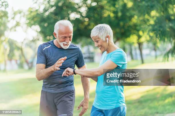 seniorenpaar mit sporttechnologien - pedometer stock-fotos und bilder