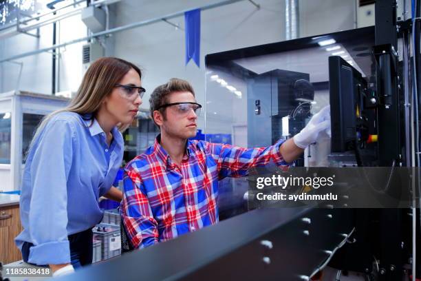 colleghi di lavoro che utilizzano il computer nella linea di produzione industriale - stampante 3d foto e immagini stock