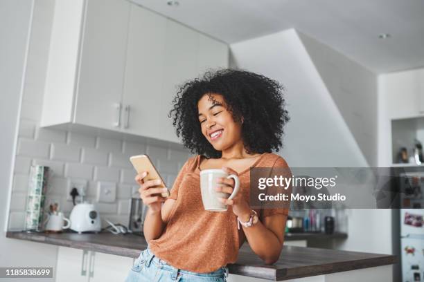 iedereen houdt van die goedemorgen berichten - woman drinking phone kitchen stockfoto's en -beelden