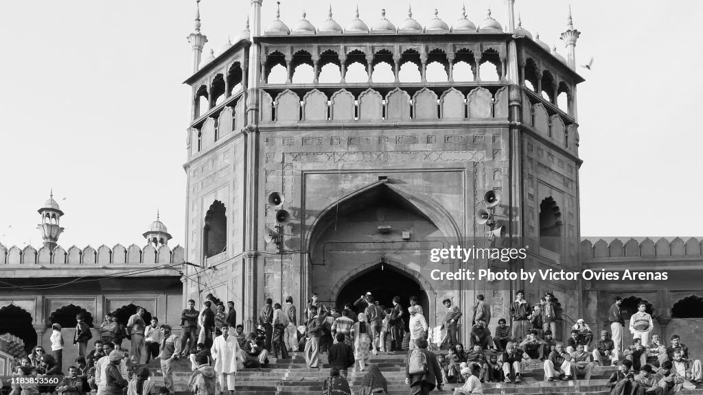 People sitting on the steps of the main gate entrance to Jama Masjid Mosque in Delhi, India