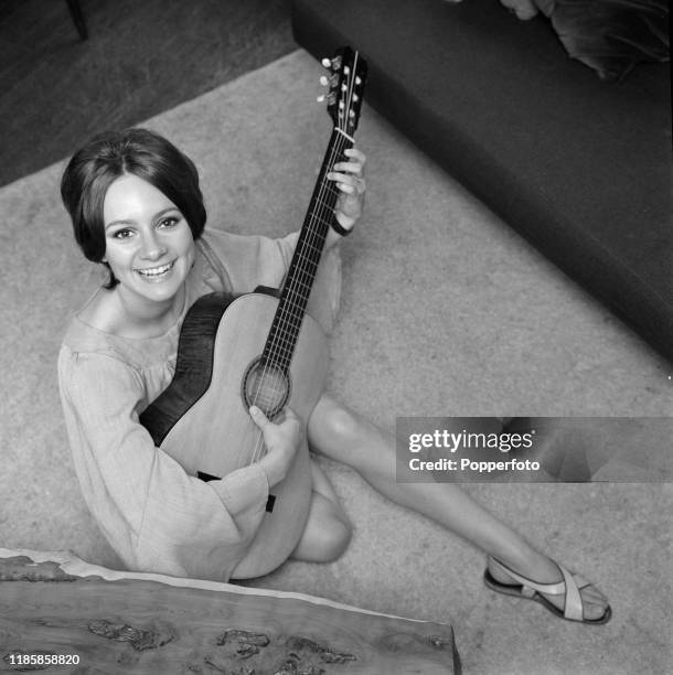 English actress Francesca Annis posed at home playing an acoustic guitar in September 1966.