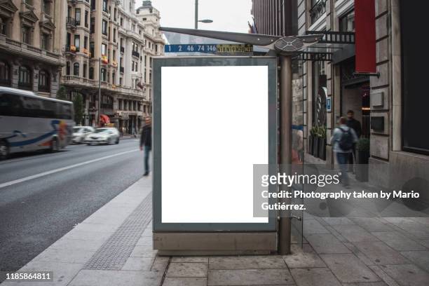 bus stop with billboard - busfahrt stock-fotos und bilder