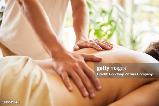 mannelijke massage therapeut werkt op een vrouw terug - masseren stockfoto's en -beelden