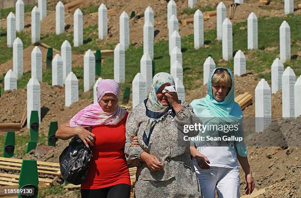 An elderly woman weeps after visiting a gravesite among the thousands of victims of the 1995 Srebrenica massacre buried at the Potocari cemetery and...