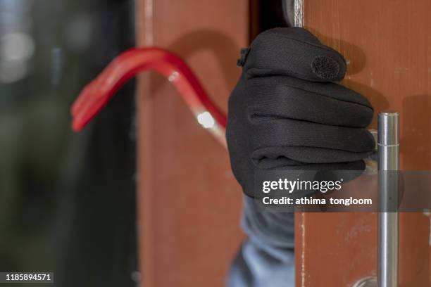 thief with a bar of iron in the hand to open a door - burglary stock pictures, royalty-free photos & images