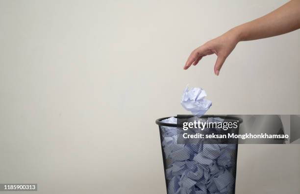 woman hand throwing crumpled paper in basket - jetée photos et images de collection