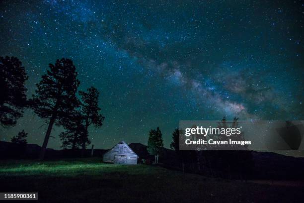 milky way over a barn in colorado's san juan mountains - aurora colorado stock-fotos und bilder