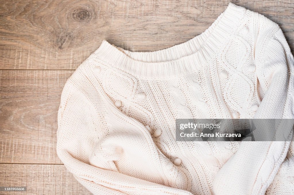 Women's autumn, winter clothes - white knitted pullover oversize, top view. Flat lay.