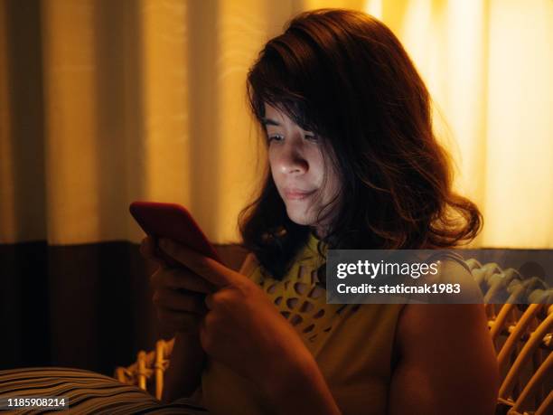 asiatische frau mit smartphone spät in der nacht. - dark room stock-fotos und bilder