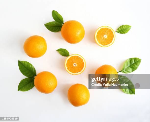 oranges fruits composition with green leaves and slice on white wooden background, copy space. - citrus fruit background stock pictures, royalty-free photos & images