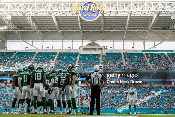 Taco Charlton of the Miami Dolphins looks on as the New York Jets huddl fourth quarter at Hard Rock Stadium on November 03, 2019 in Miami, Florida.