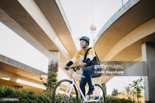 young woman with bike and messenger bag in the city - cycling helmet stock pictures, royalty-free photos & images