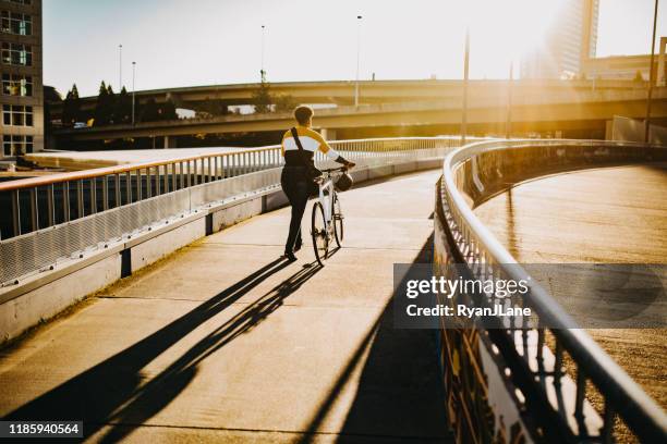 young woman with bike and messenger bag in the city - tacoma stock pictures, royalty-free photos & images