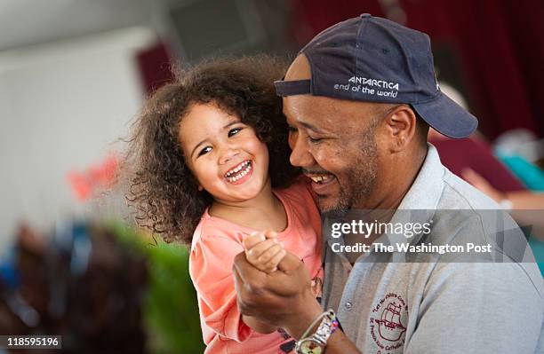 Two-year-old Natalia Wills, of Mount Ranier, MD, left, dances with her dad, James Wills. Smithsonian Folklife Festival goers dance to the music of...
