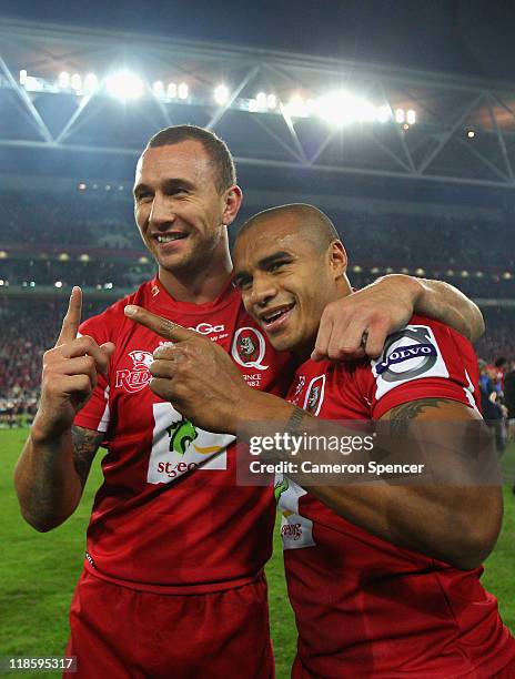 Quade Cooper of the Reds celebrates with team mate Will Genia after winning the 2011 Super Rugby Grand Final match between the Reds and the Crusaders...