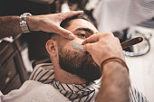 Barber shaves the beard of the client
