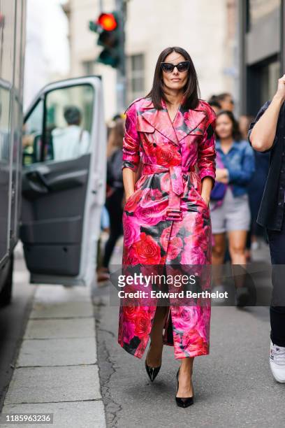 Paola Turani wears sunglasses, a pink floral print leather trench coat, outside the Blumarine show during Milan Fashion Week Spring/Summer 2020 on...