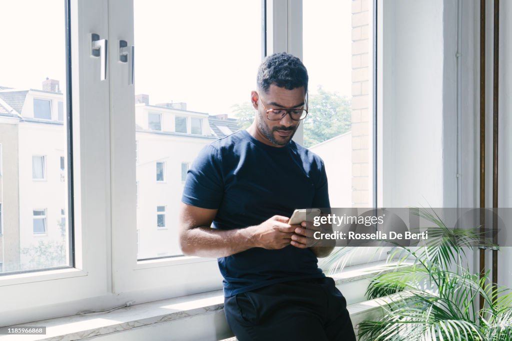 Retrato de um homem novo no telefone dentro