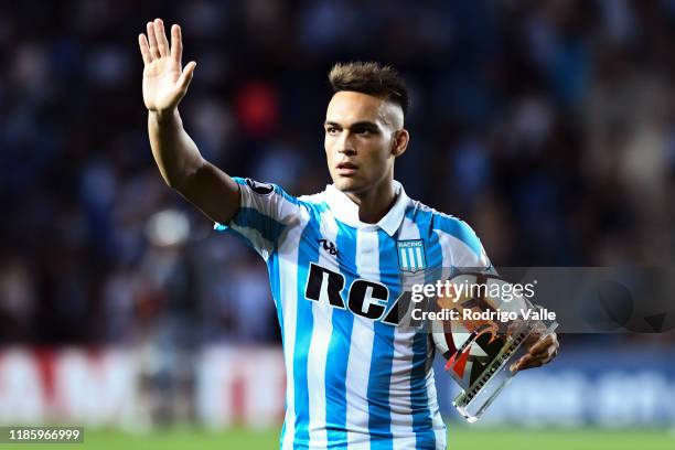 Lautaro Martinez of Racing Club takes the match ball after scoring a hat trick at the end of a Group E match between Racing Club and Cruzeiro as part...