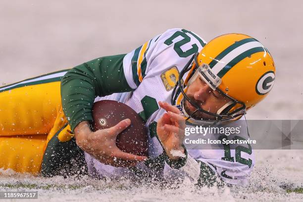 Green Bay Packers quarterback Aaron Rodgers slides in the snow during the third quarter of the National Football League game between the New York...