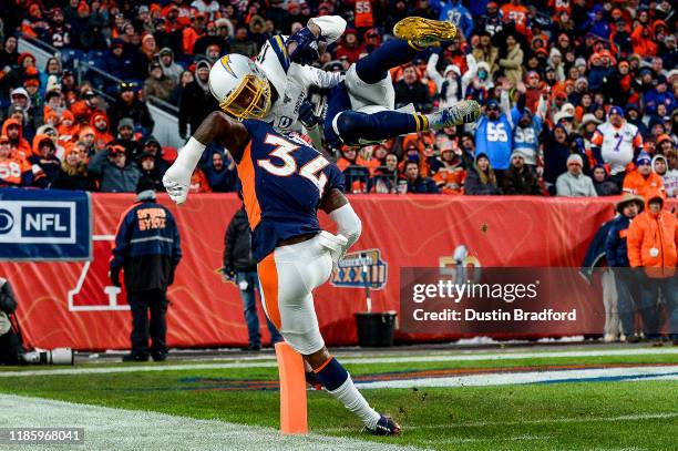 Keenan Allen of the Los Angeles Chargers leaps over Will Parks of the Denver Broncos to score a third quarter touchdown on a reception at Empower...