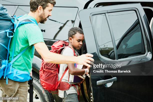 father opening car door for son before going on camping trip - entering stock pictures, royalty-free photos & images